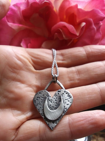 silver heart pendant in hand
