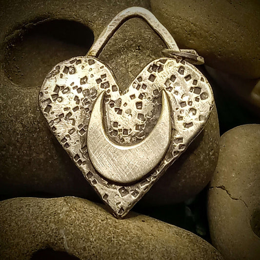 Silver heart shaped pendant with a crescent moon inside